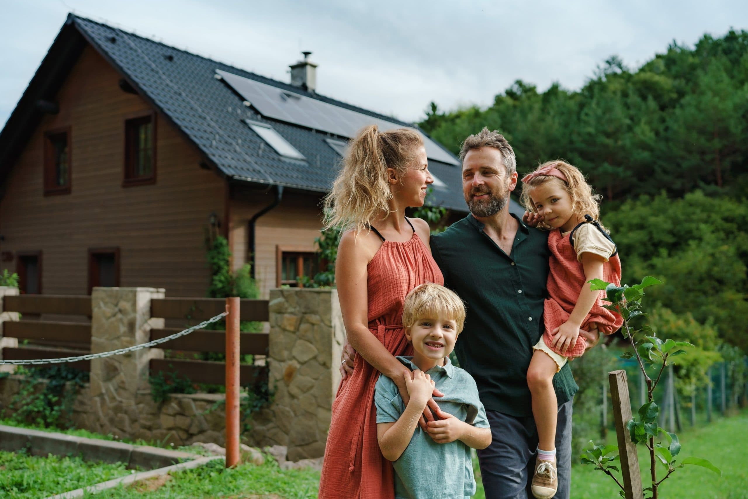 Familie vor ihrem Haus mit Solaranlage